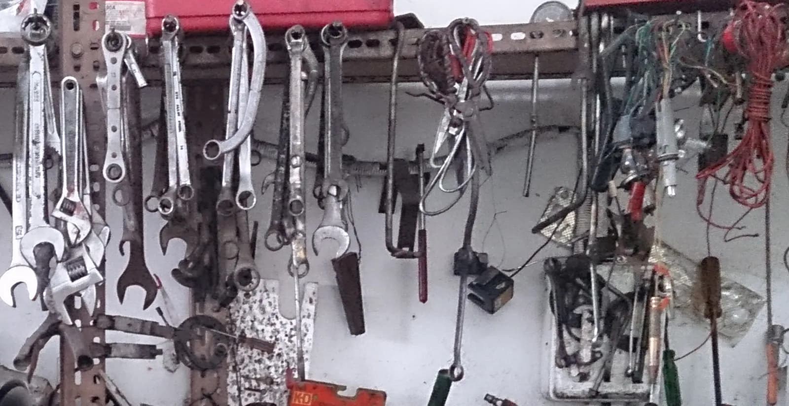 Clés plates, tournevis et boîtes à outils rangés au mur d'un atelier automobile